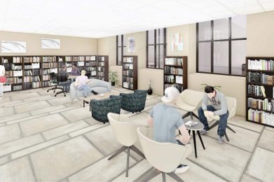 Library interior with bookshelves, seating area, and people reading.